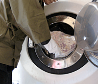 丸洗い（ドライクリーニング）機械に着物を入れる写真